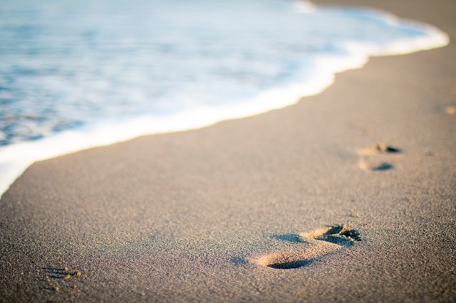 stopy na pláži v piesku